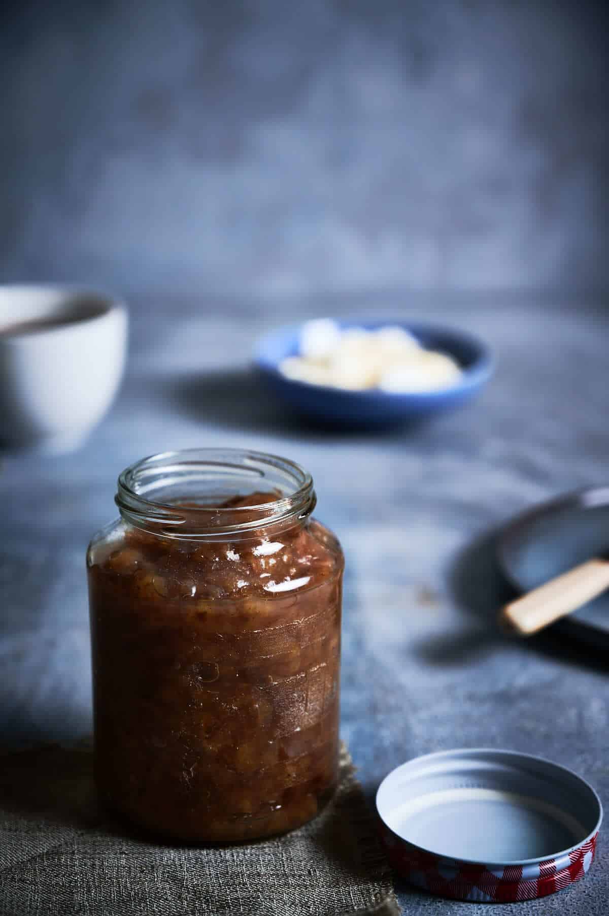 a jar of banana jam on a grey table