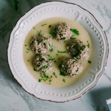 a white bowl filled with meatballs in a soup