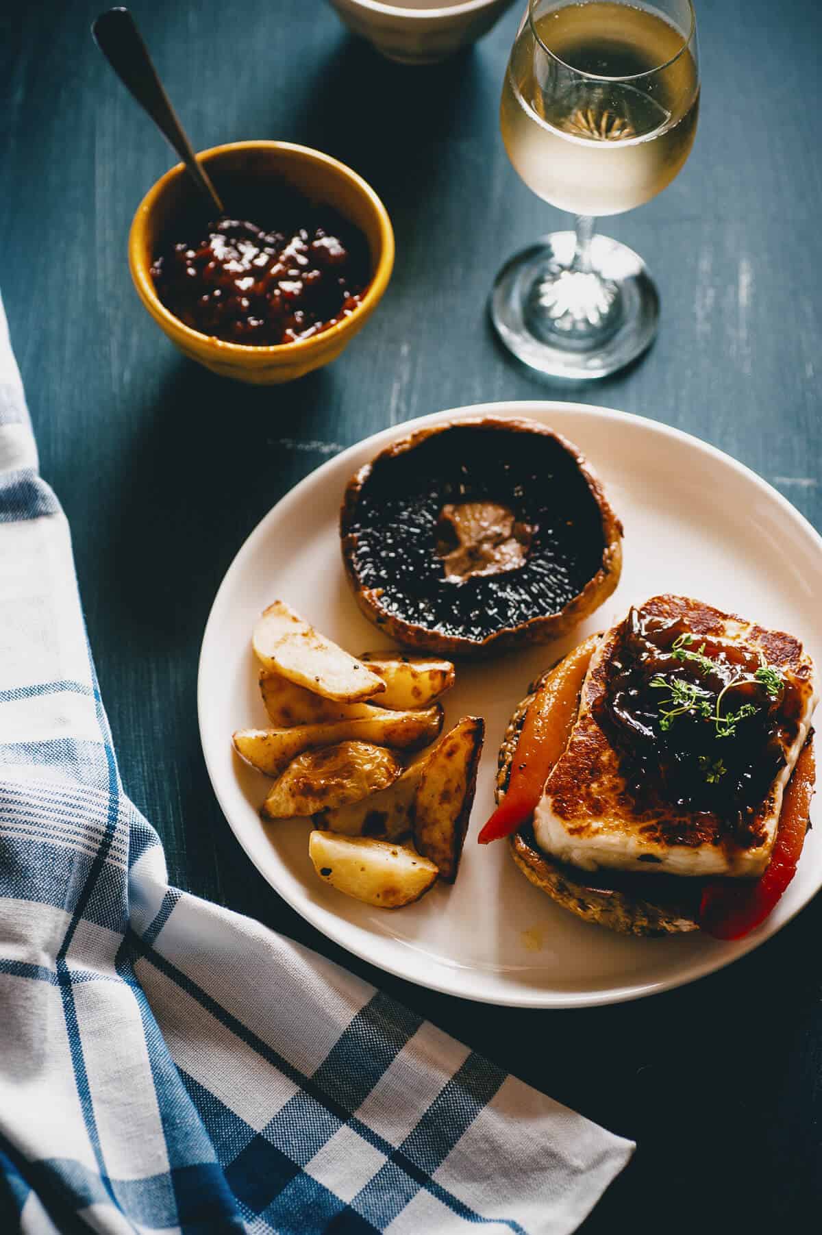 a plate with tow mushrooms and potatoes served with relish