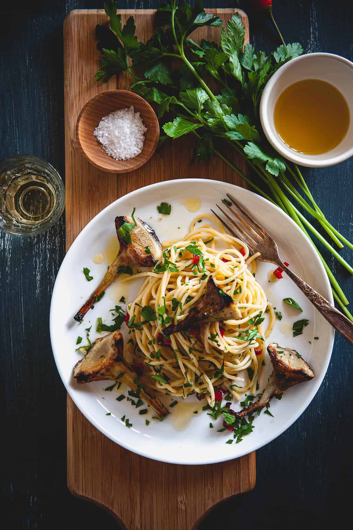 spaghetti with artichokes served in a plate on a board