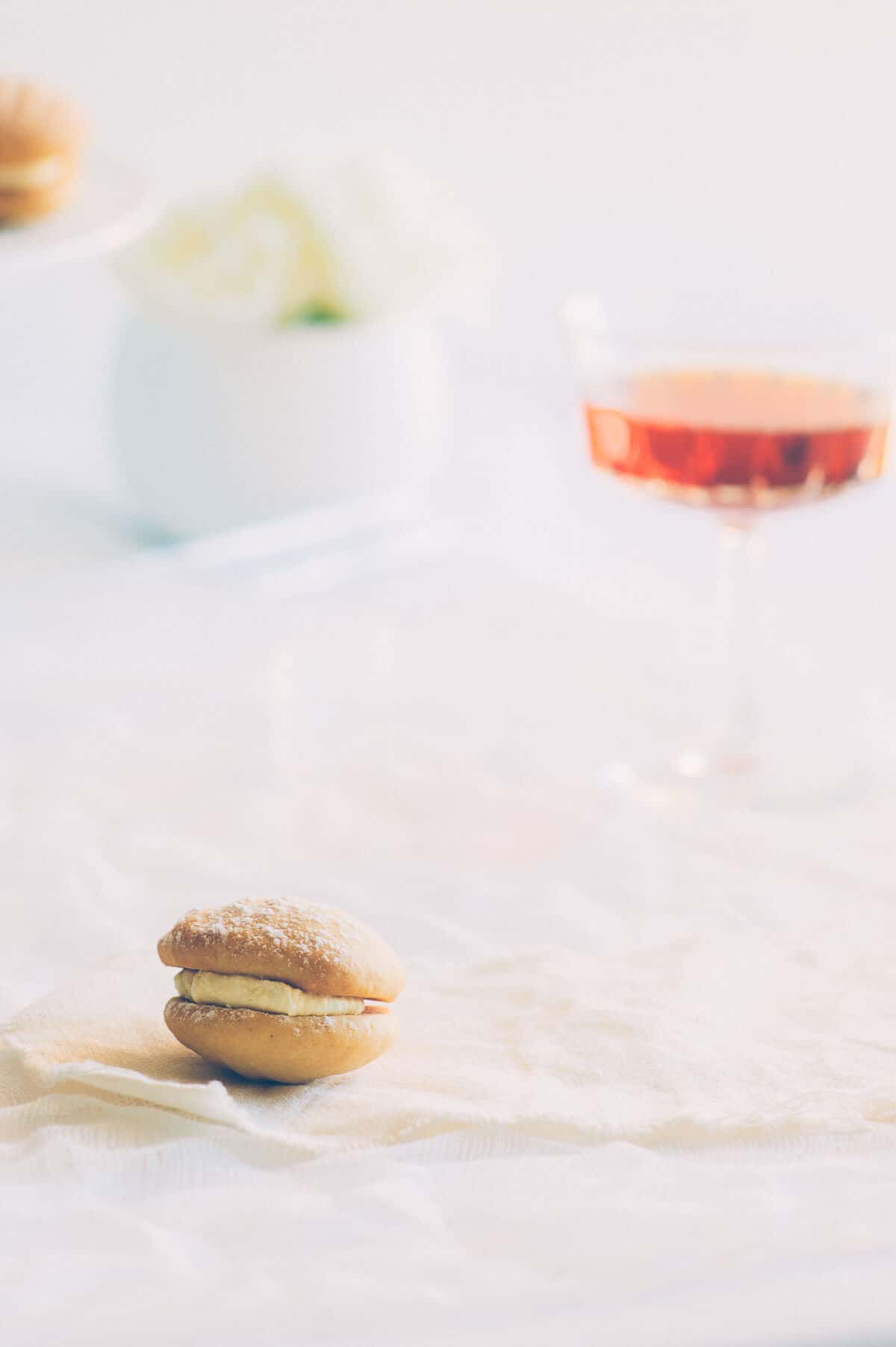 a cookie with a glass of wine presented in the background