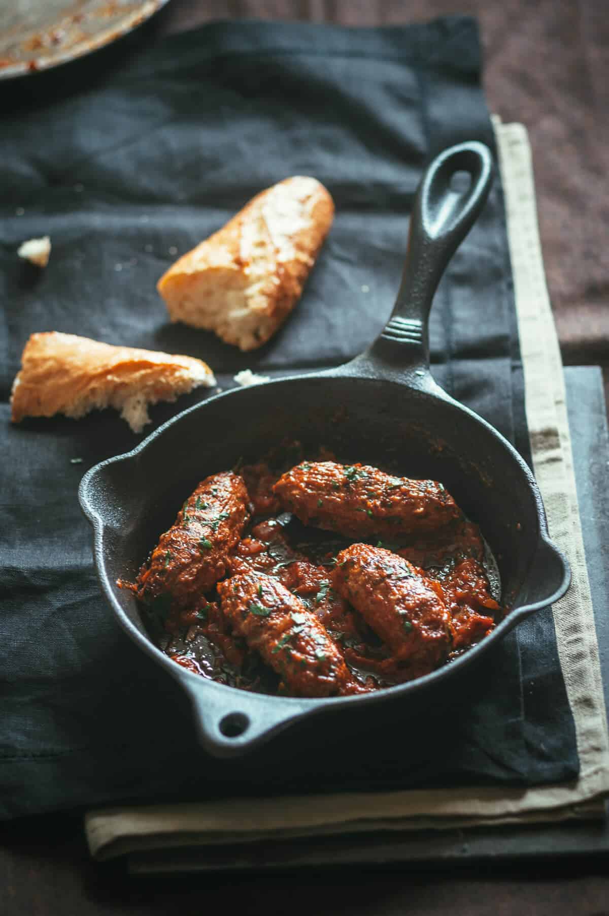 4 oblong meatballs served in a black cast iron pan