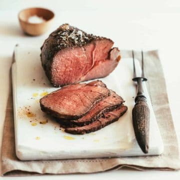 sliced roast beef served on a white board