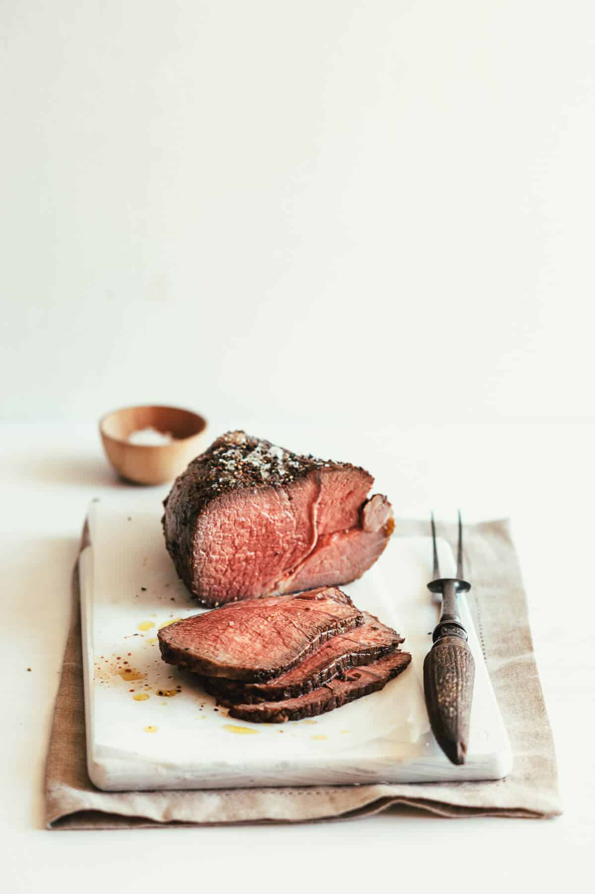 sliced roast beef served on a white board