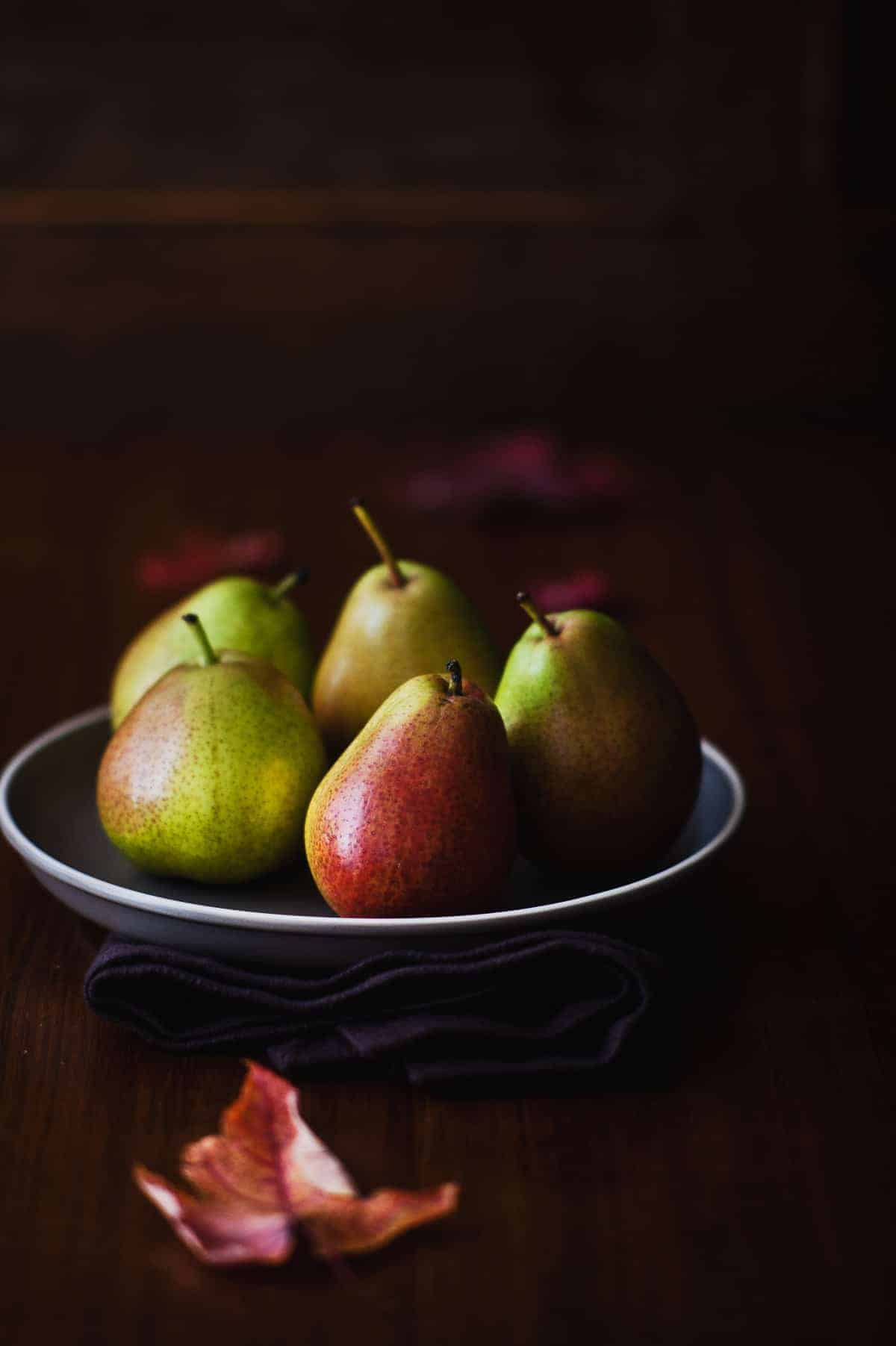 five pears on a grey plate