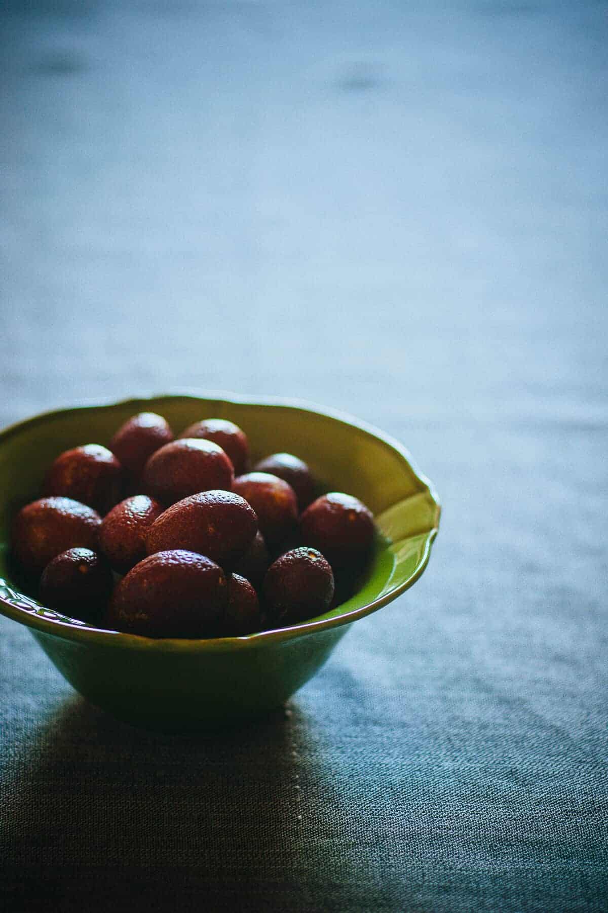 a green bowl filled with blood limes