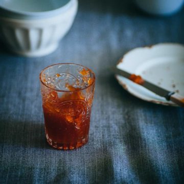 a glass filled with marmalade on a grey table