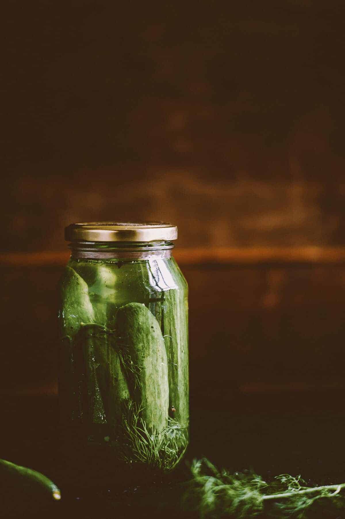 a glass jar full of pickled cucumbers