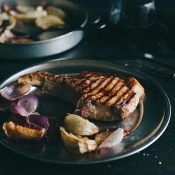 cooked pork cutlets served with vegetables on a plate