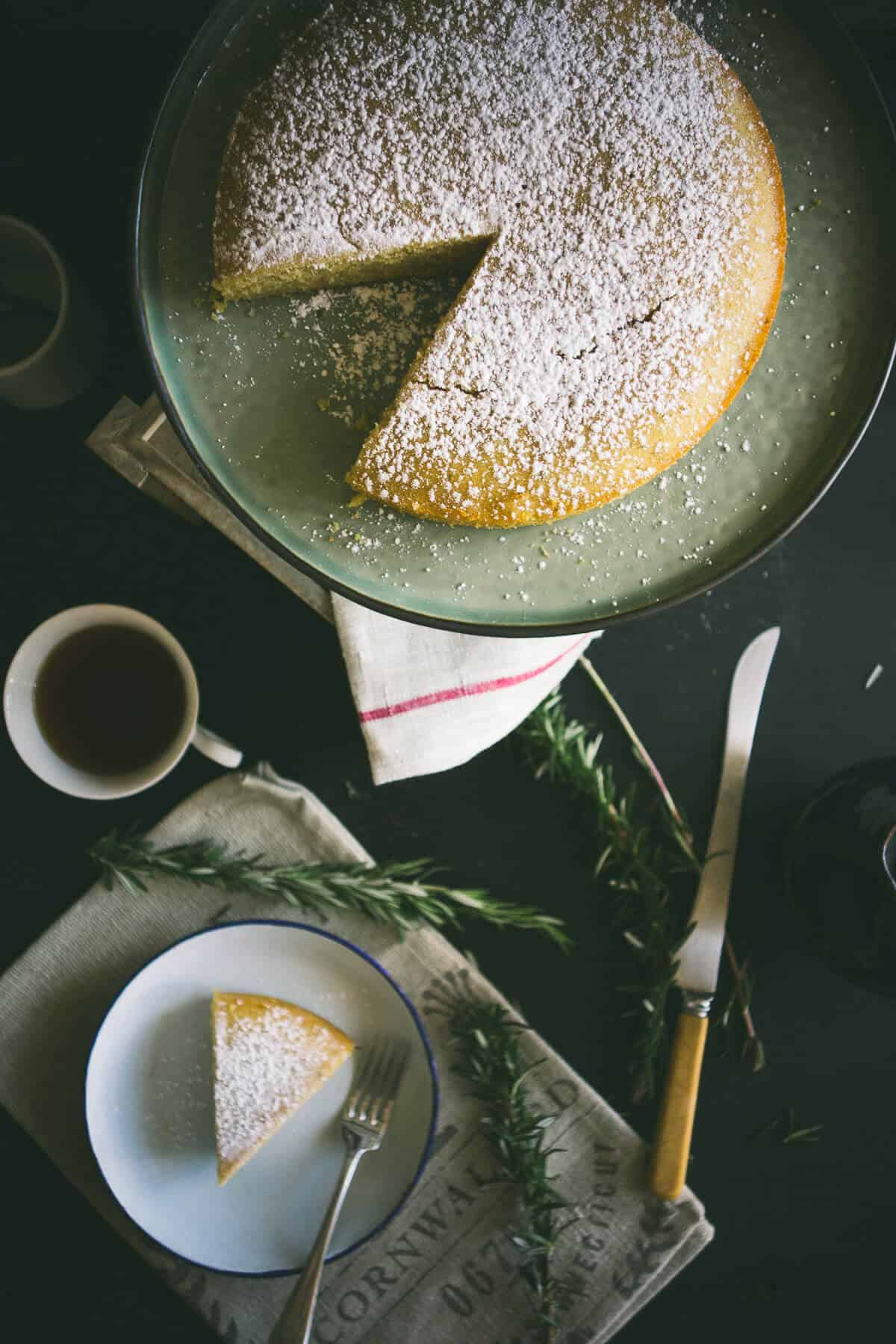 a birds eye view of a sliced cake with a cup of tea and a knife next to it