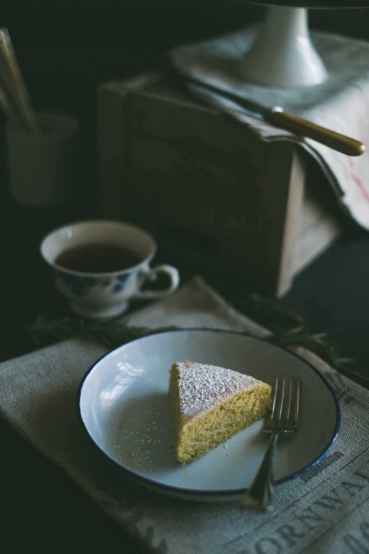 a slice of lemon rosemary olive oil cake  served on a plate 