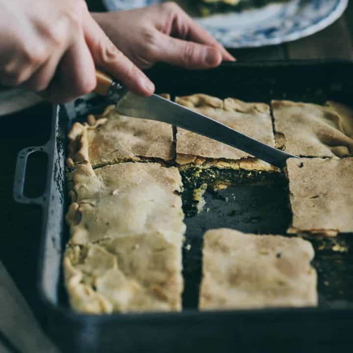 hortopita Greek style wild greens pie served in a baking pan.