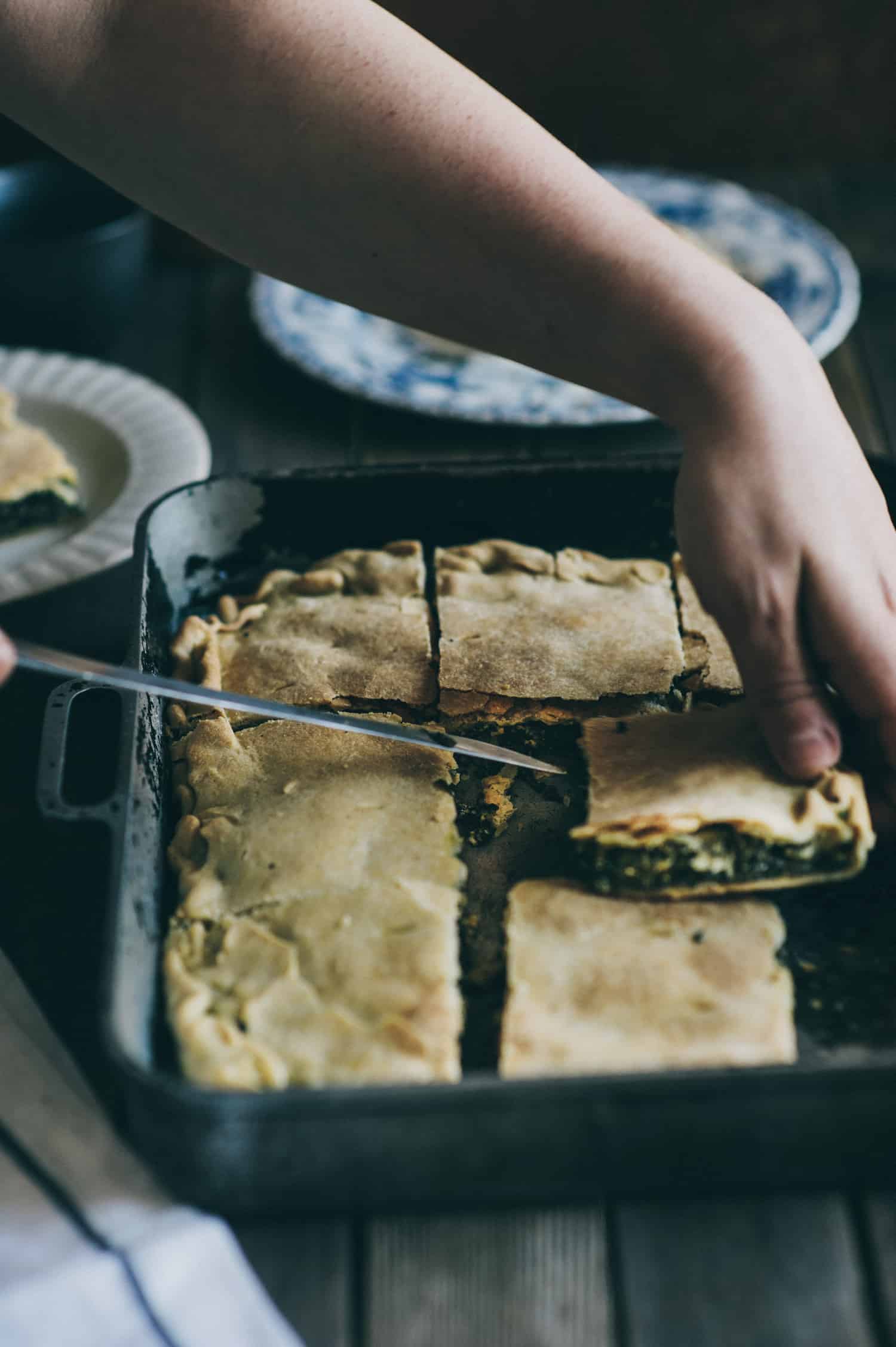 a hand slicing a piece of pie