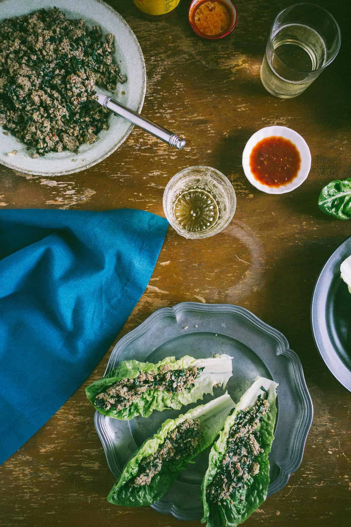 cooked mushrooms on a plate with another plate next to it filled with lettuce leaves stuffed with cooked mushrooms