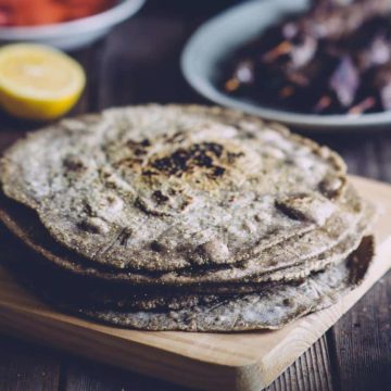 a stack of buckwheat pita bread on a wooden board