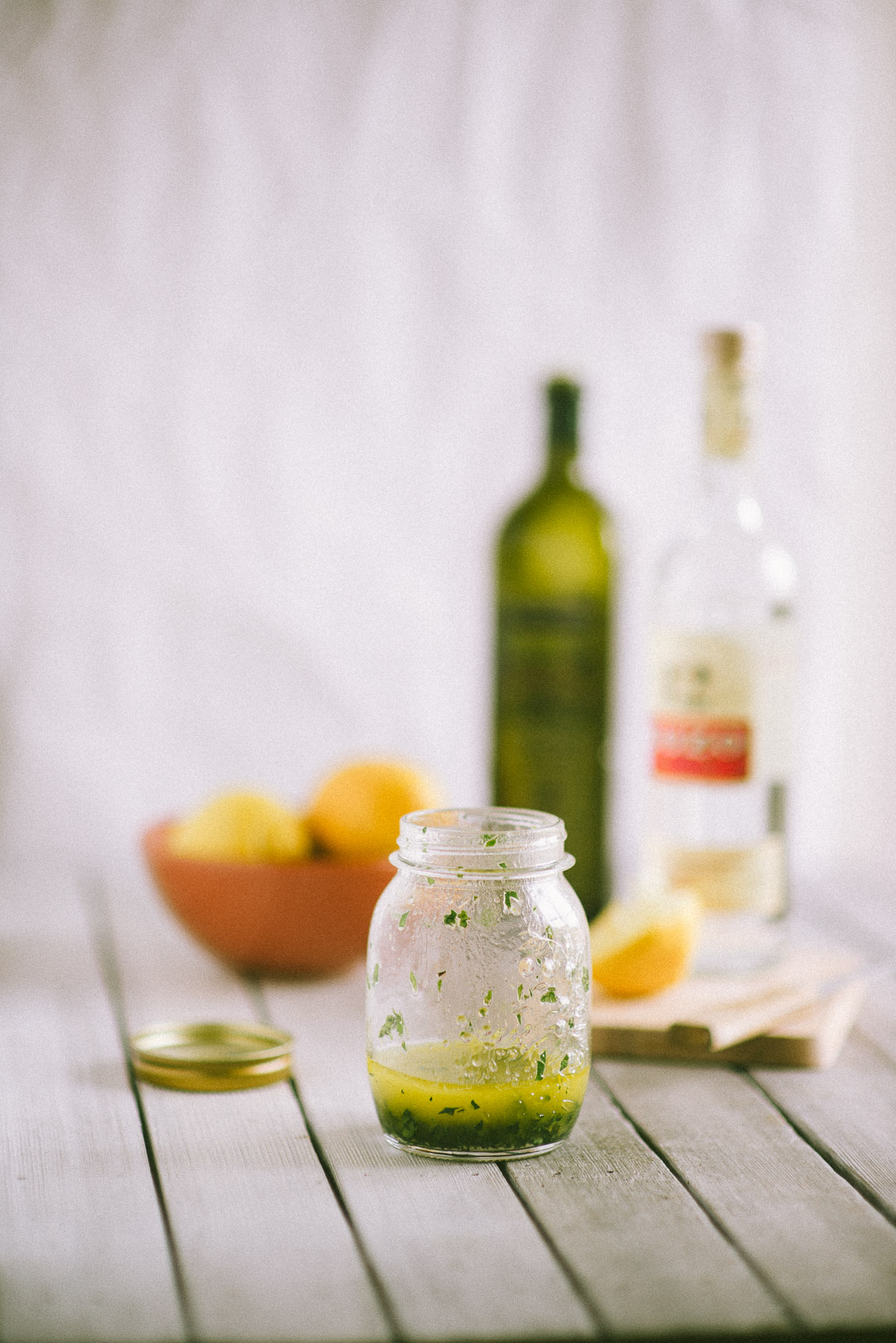 a jar of salad dressing made suing ouzo on a table 