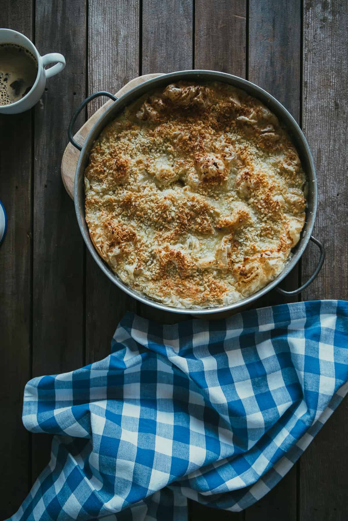 a pie made with fillo and a coconut custard in a baking dish on a rustic table