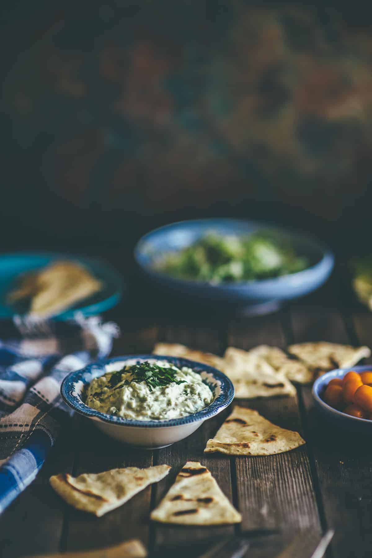 a bowl of tzatziki made with the addition of avocado. Served with Greek pita bread on the side