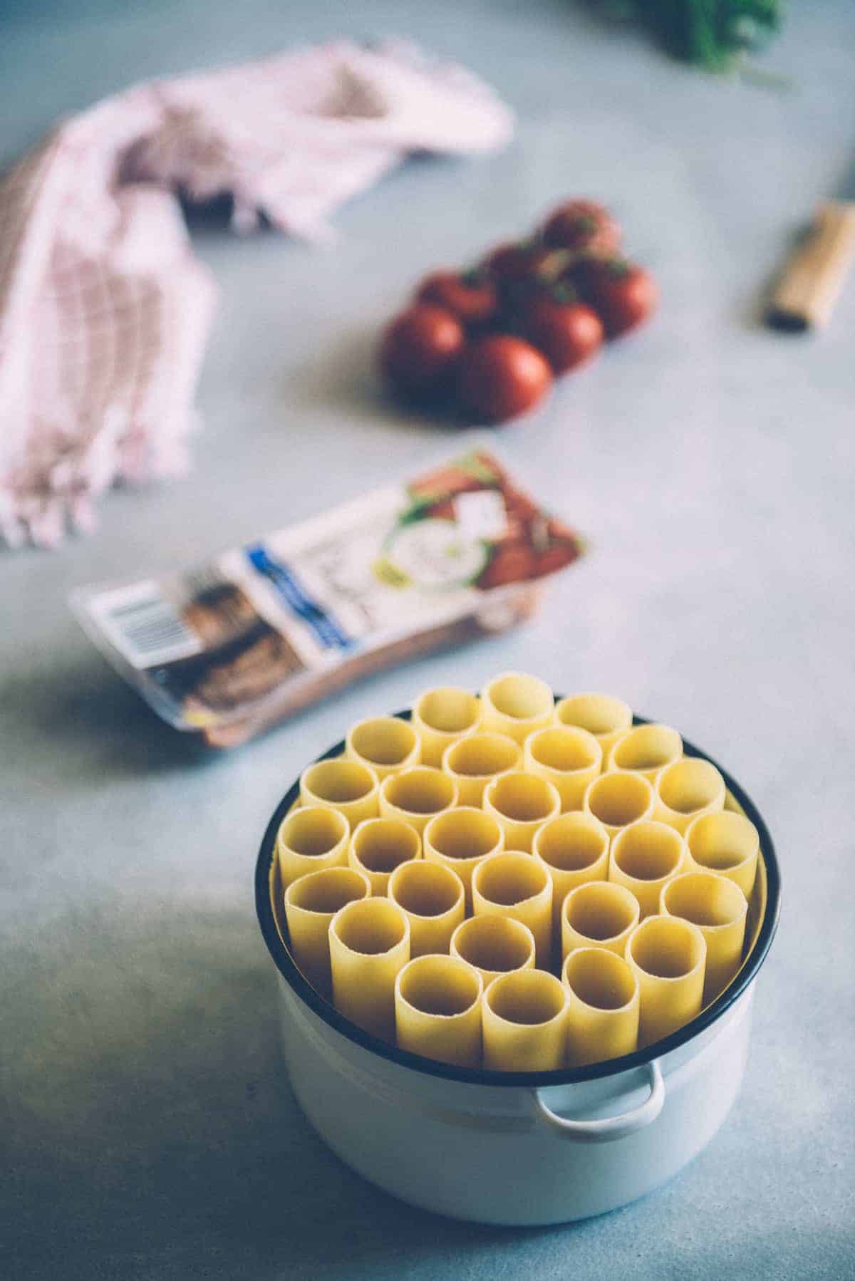 cannelloni tubes stacked vertically in a baking dish