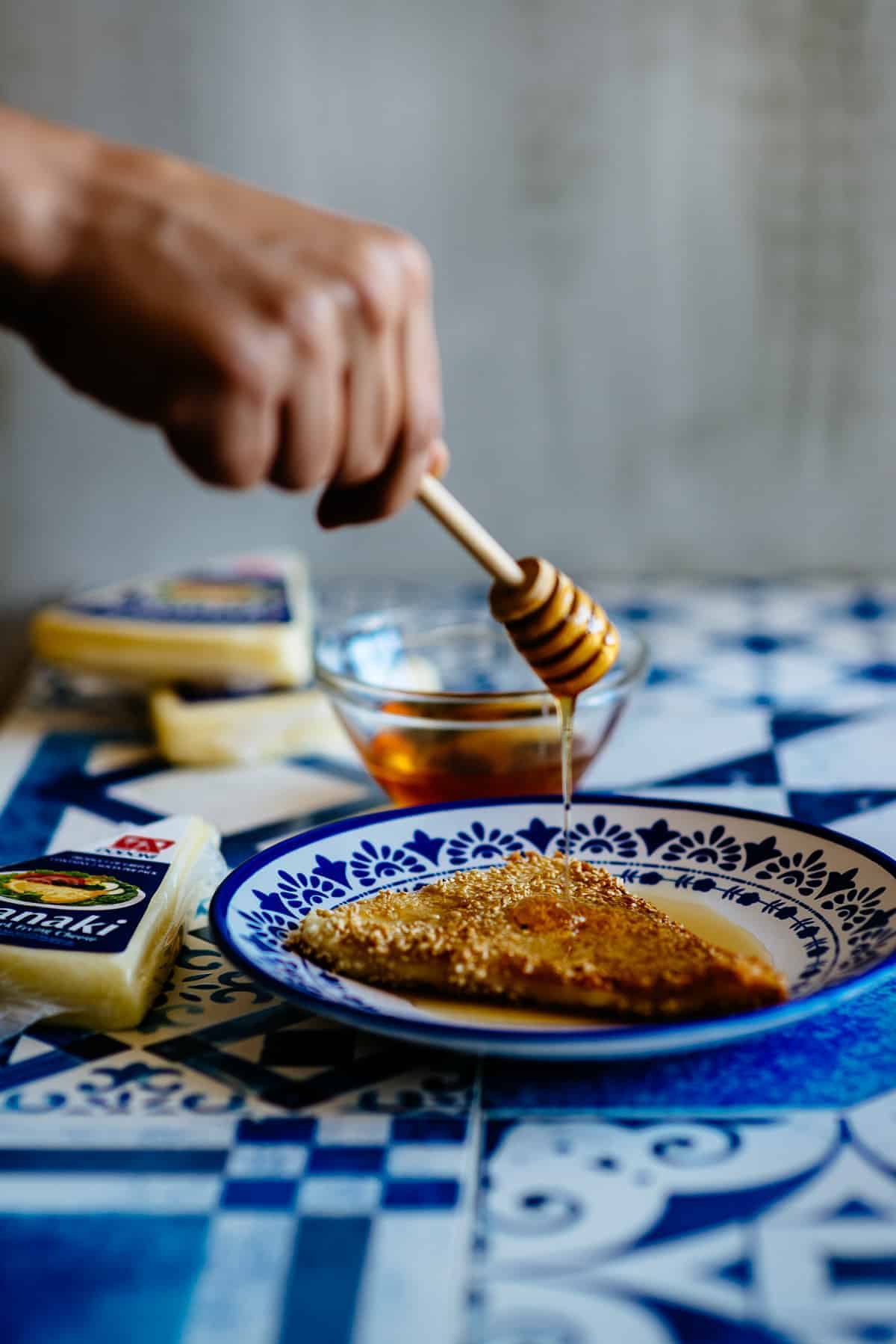 drizzling honey over fried saganaki cheese