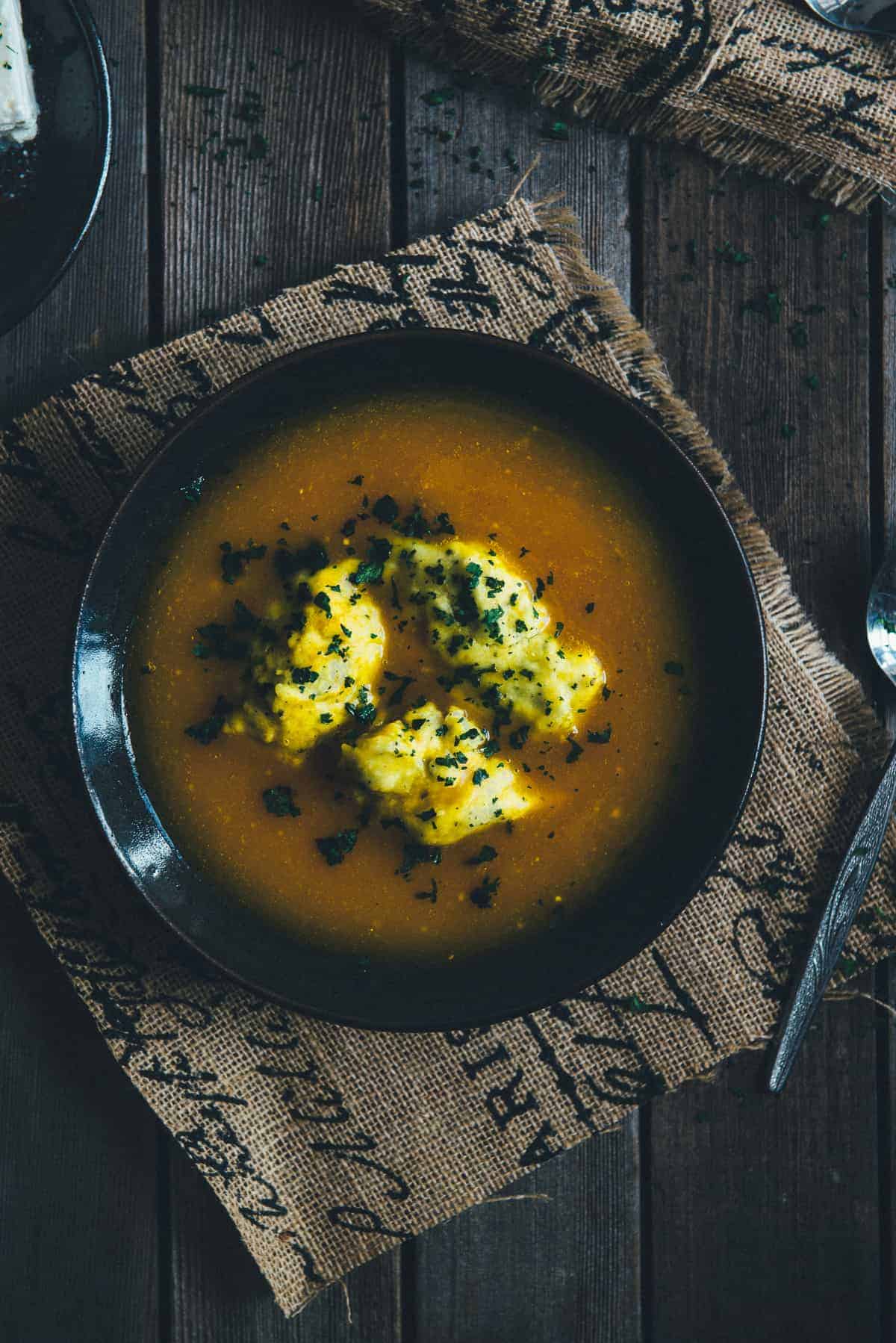 little balls of dough made with feta served on top of pumpkin soup