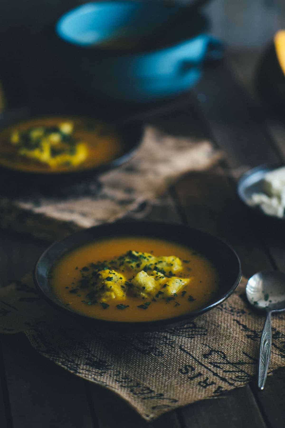 little balls of dough made with feta served on top of pumpkin soup