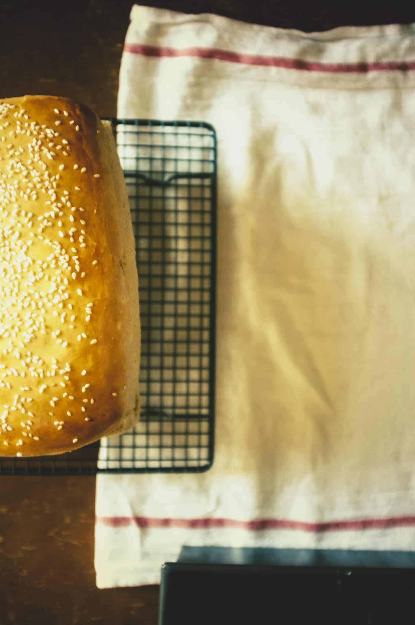 a loaf of brioche bread cooling on a rack