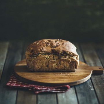 a loaf of fig and walnut bread on a chopping board