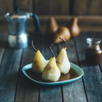 poached pears served on a blue plate