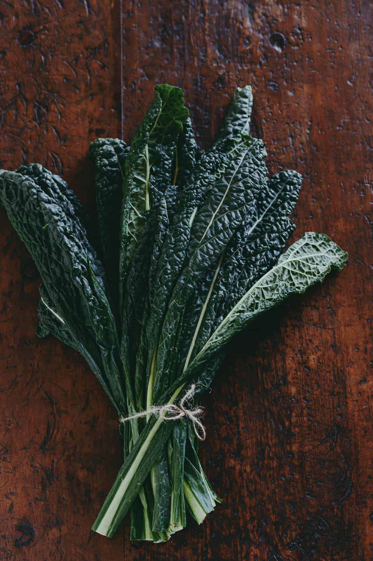 a bunch of cavolo nero (black kale) on a wooden table