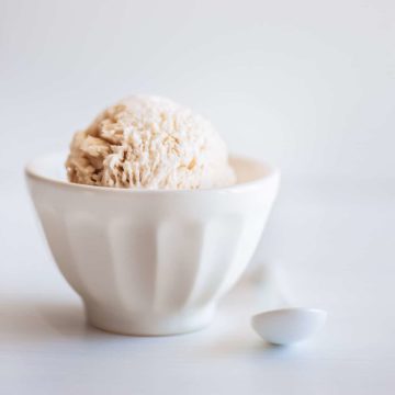 a scoop of cinnamon ice cream served in a white bowl