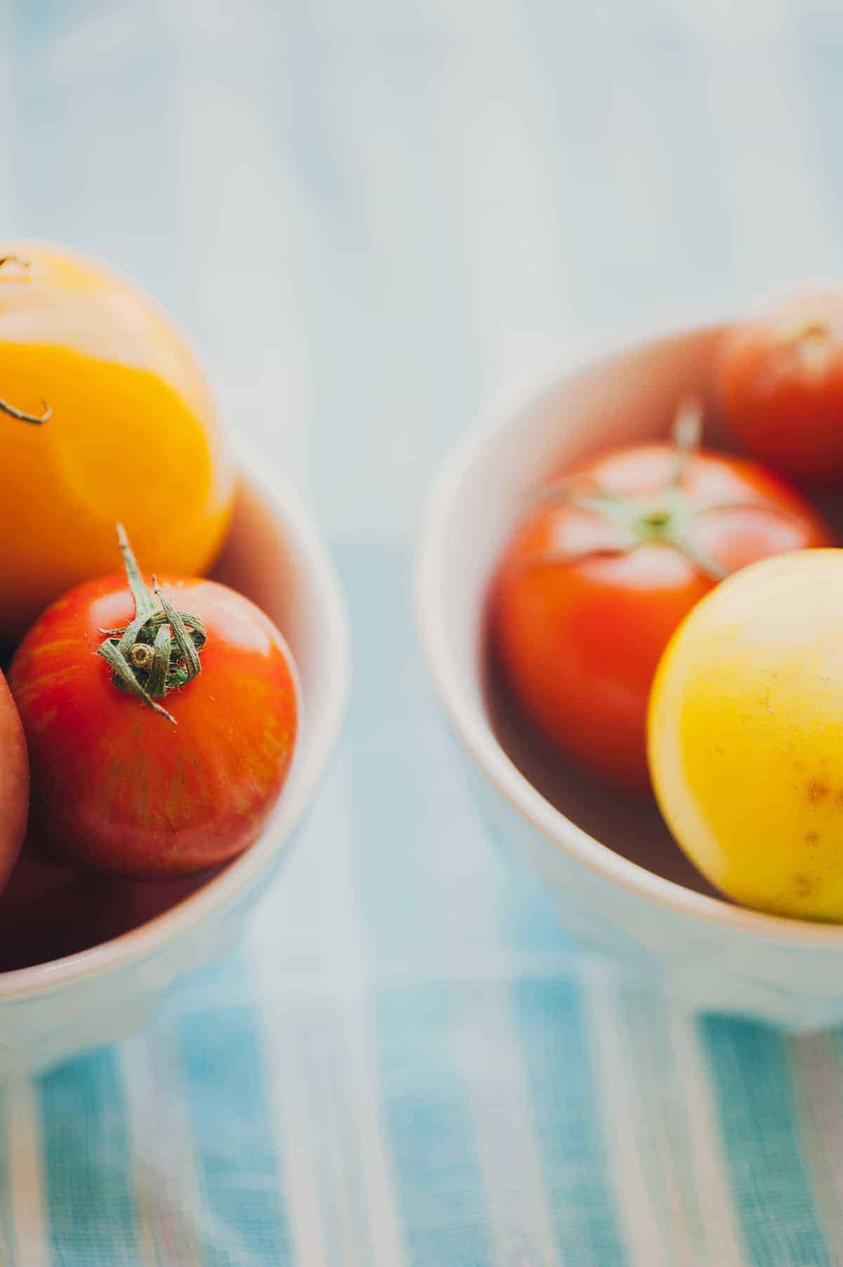 2 bowls filled with yellow and red tomatoes