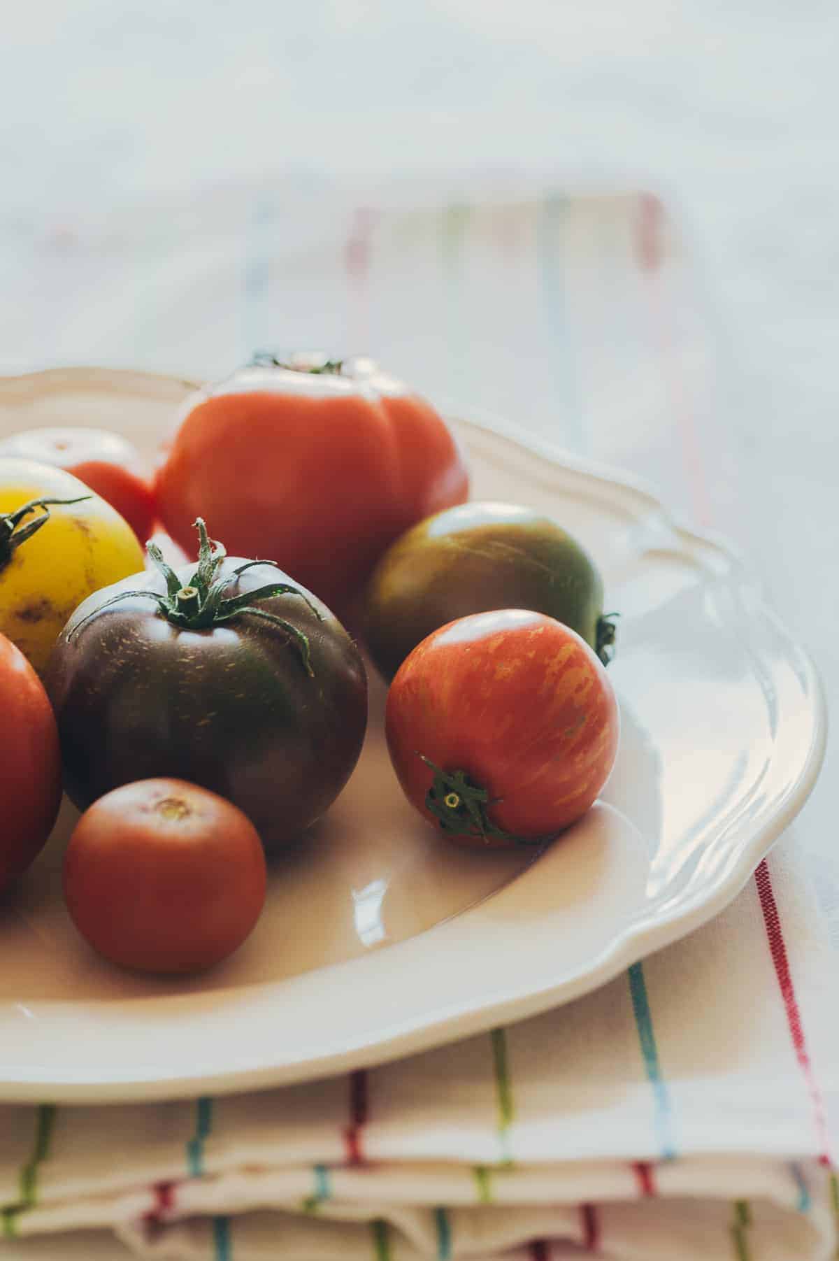 a white plate filled with a variety of coloured tomatoes