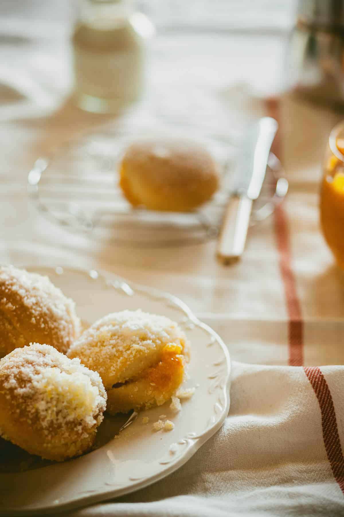 a plate of doughnuts filled with jam served on a white plate