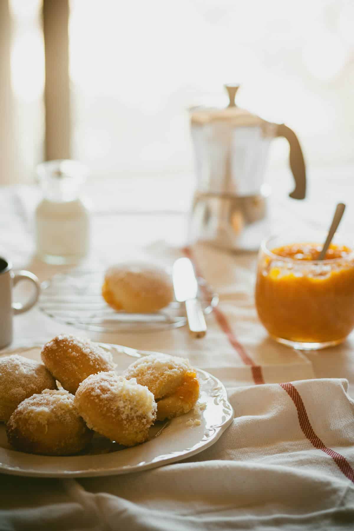 doughnuts served on a plate with coffee in the background