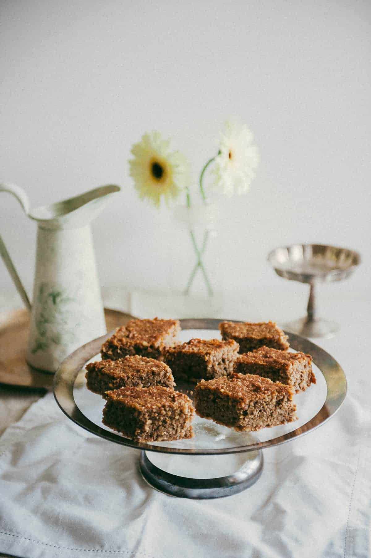 seven slices of Greek walnut cake on a glass cake stand