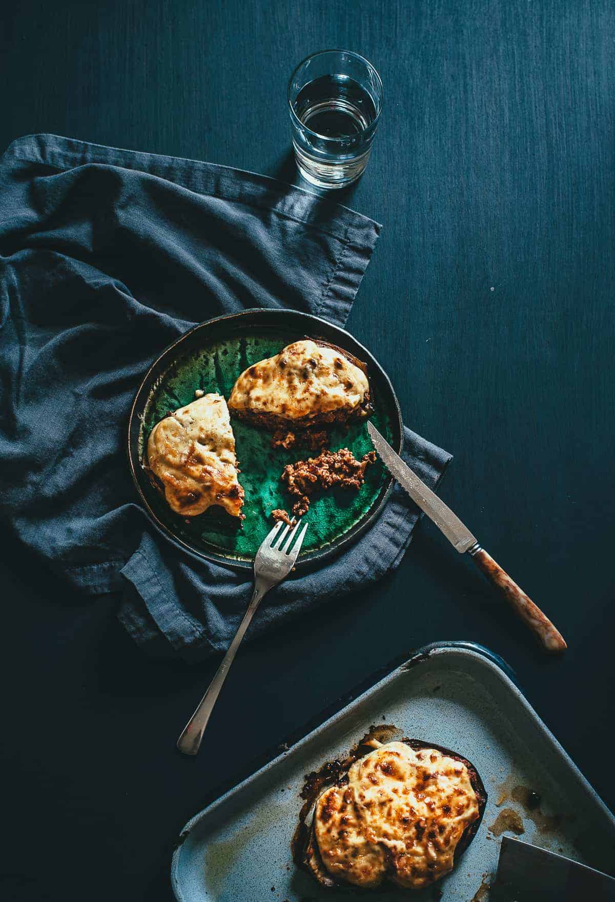 top down view of a plate with a stuffed eggplant cut in half with a knife