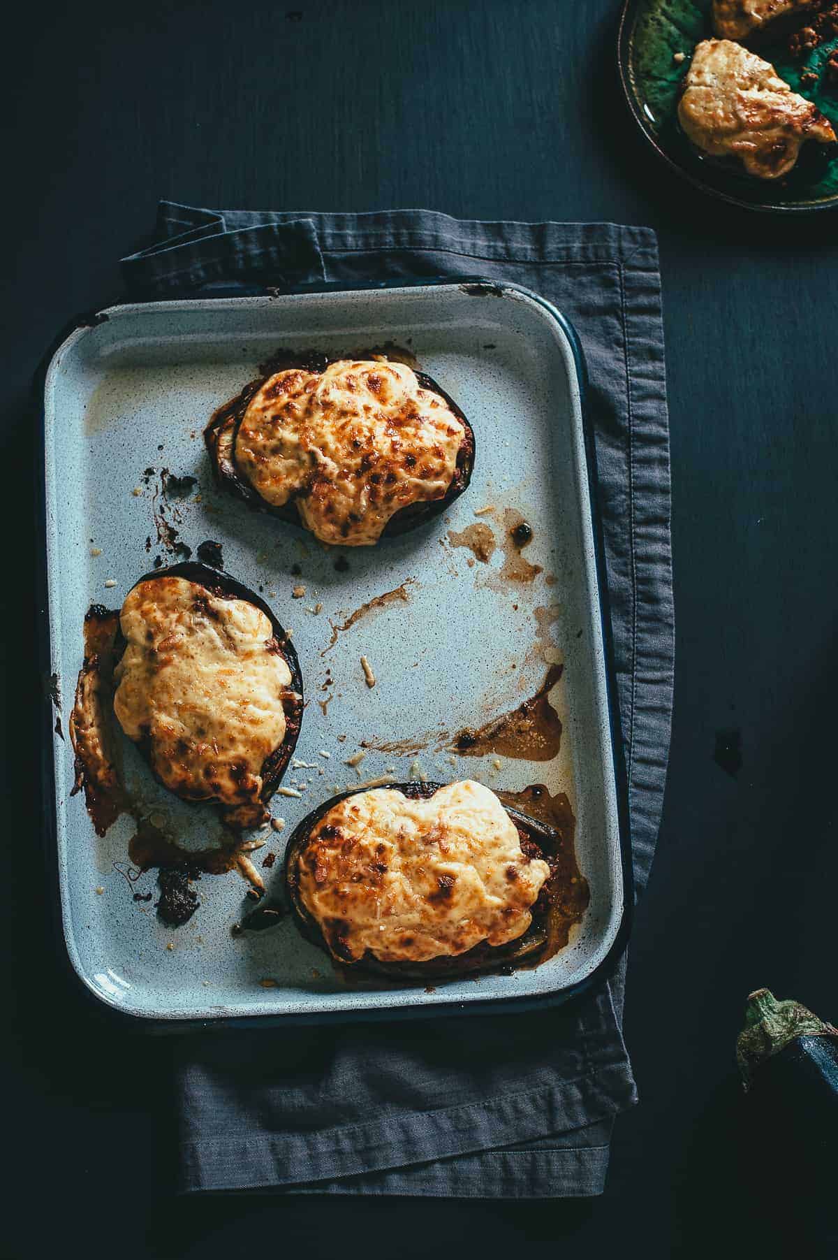 top down view of three stuffed eggplants topped with a béchamel sauce