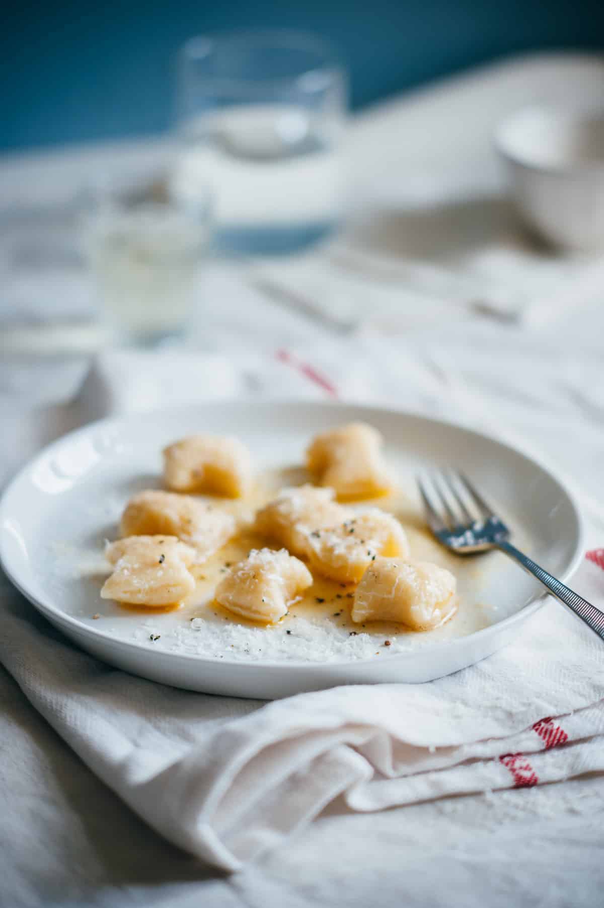 a served o ricotta gnocchi on a white plate with melted butter