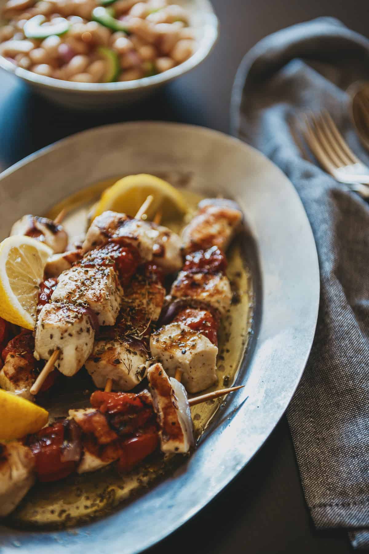 a silver platter with three serves of swordfish souvlaki