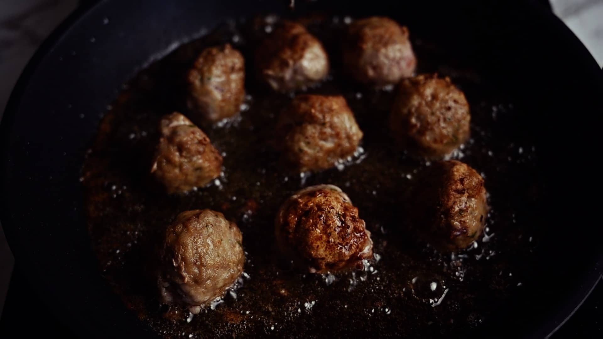 meatballs frying in a pan