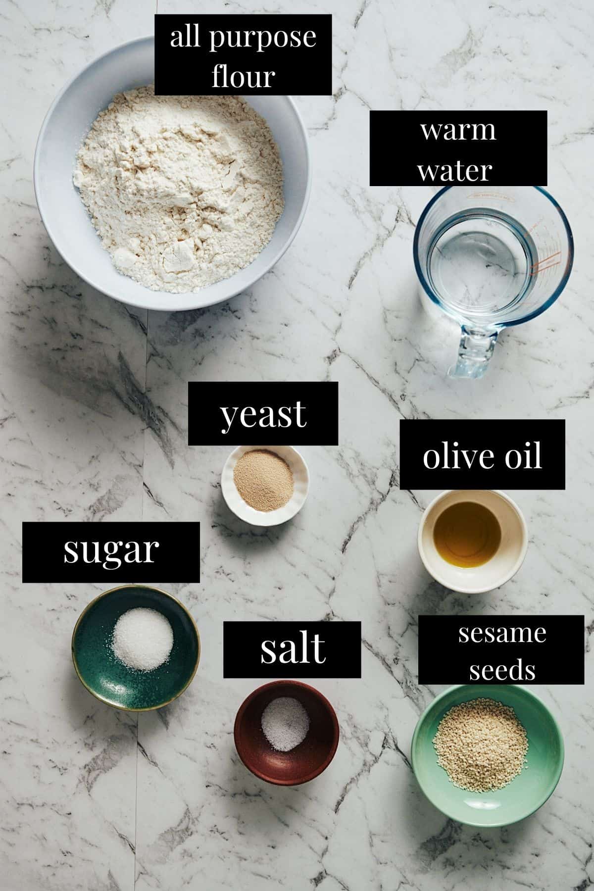 labeled ingredients laid out on a table to make greek lagana bread