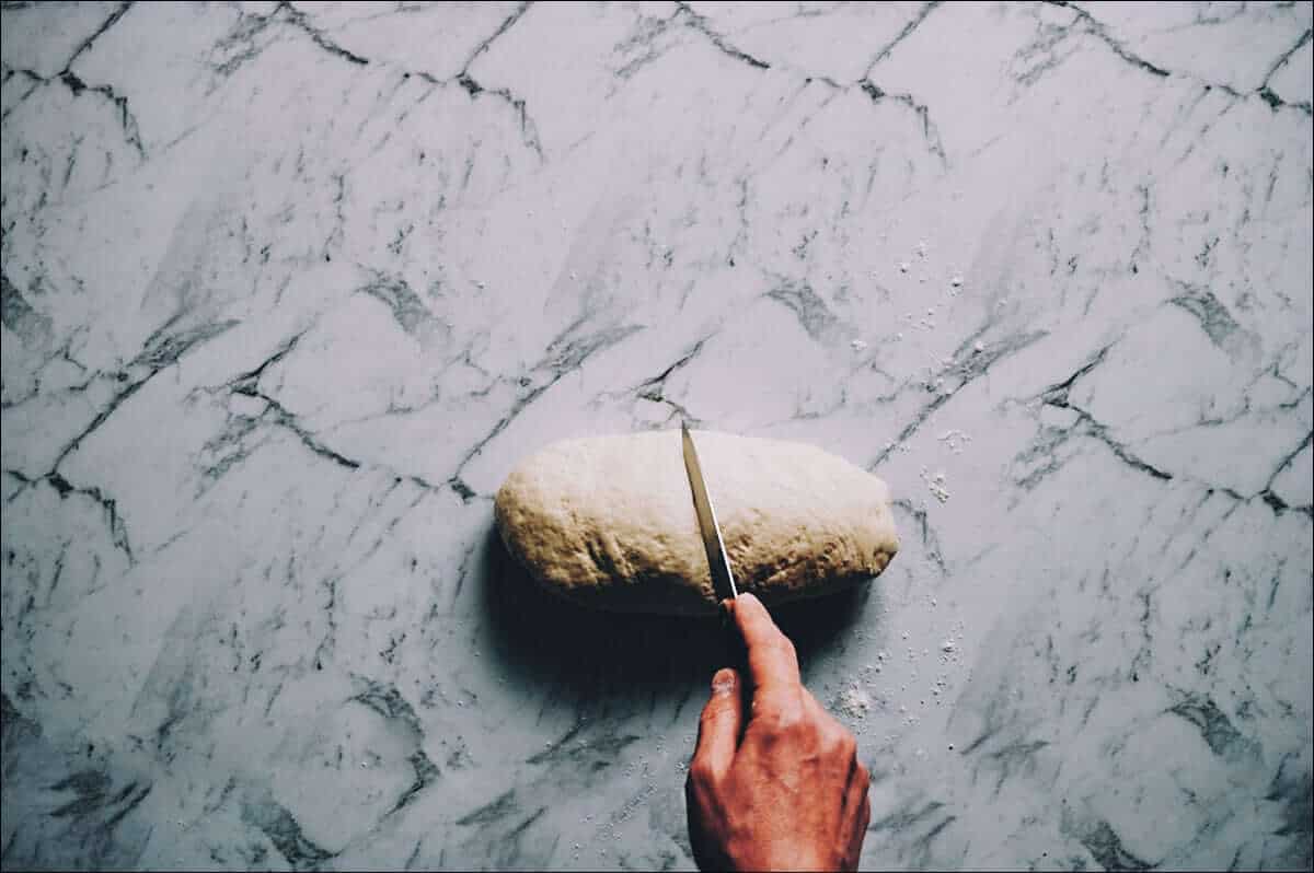 cutting dough in half with a knife