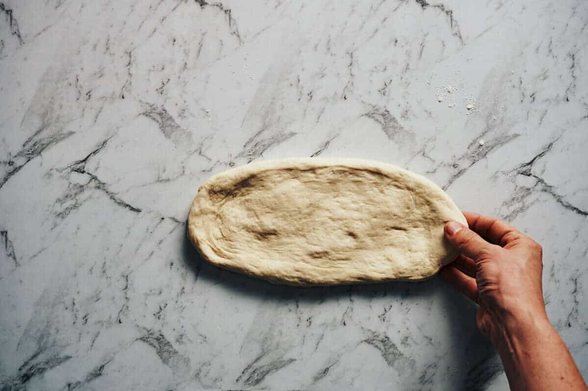 shaping a greek flatbread with a hand