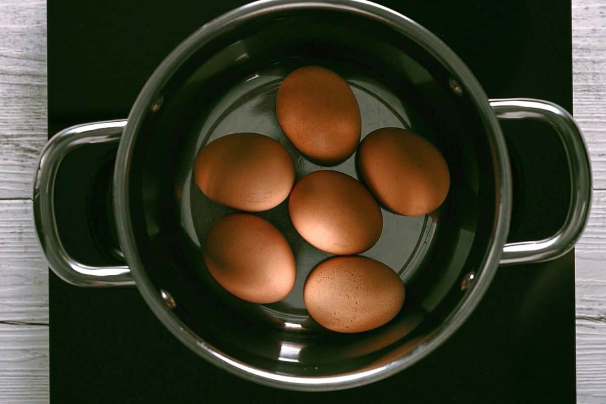 five raw eggs in a pot