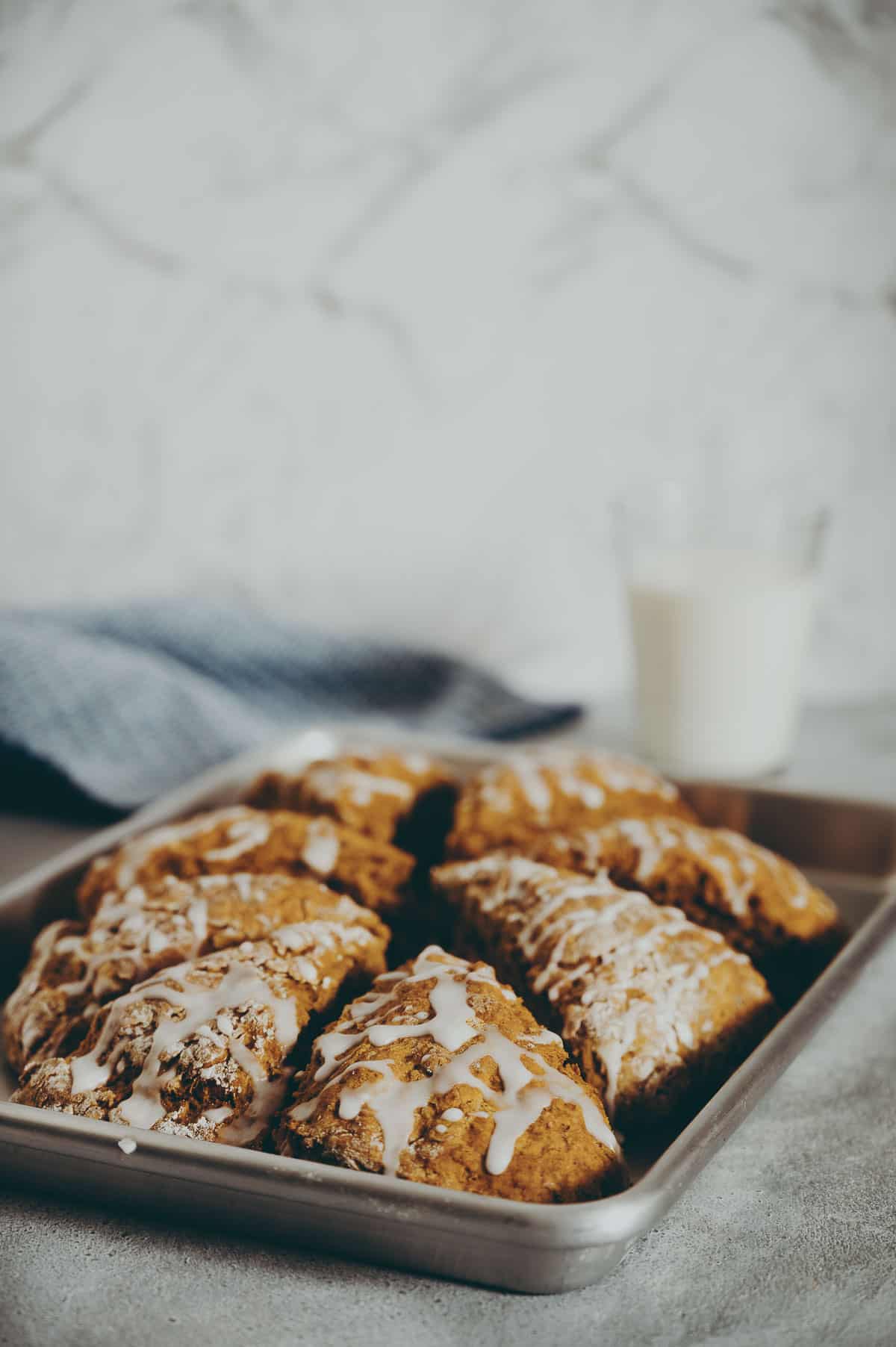 scones drizzled with glaze on a baking tray.