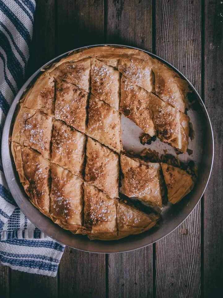 a greek pie made with filo and dusted with cinnamon and powdered sugar.
