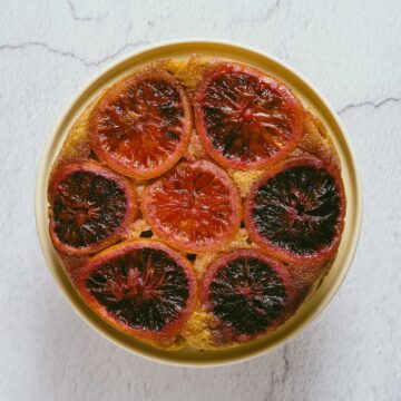 a top down view of an orange upside down cake on a cake stand.