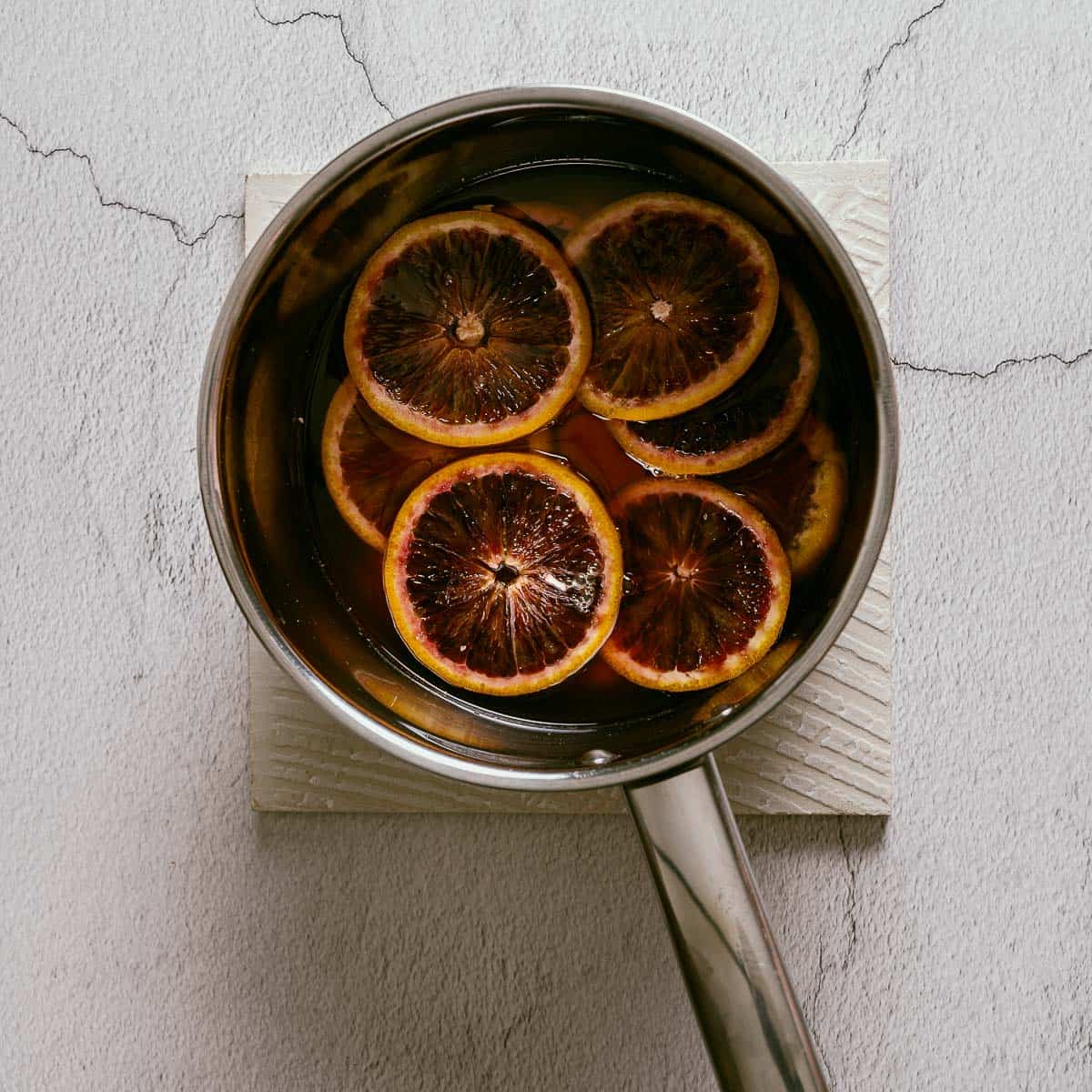 cooked blood orange slices on in a saucepan.