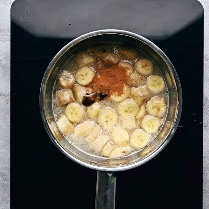 chopped bananas cooking in a pot with ground cinnamon